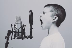 a boy screaming into a microphone