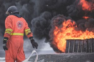 firefighter walking away from a dumpster fire